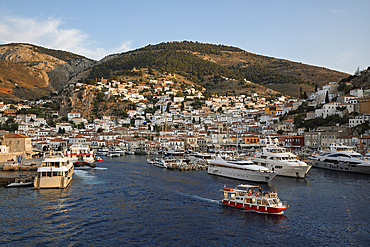 The port and whitewashed houses on hillside at sunset, Hydra, Saronic Islands, Greek Islands, Greece, Europe