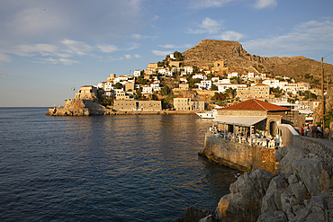 Omilos Restaurant Bar and whitewashed houses on hillside behind in evening, Hydra, Saronic Islands, Greek Islands, Greece, Europe