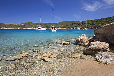 Paralia Zogerias beach with crystal clear blue water and yachts, Spetses, Saronic Islands, Greek Islands, Greece, Europe