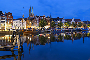 Gabled houses and boats reflected in the canal at night, Lubeck, Schleswig Holstein, Germany, Europe