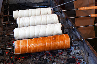 Kurtoskalacs (chimney cake) (stove cake) cooking over coals, Budapest, Hungary, Europe