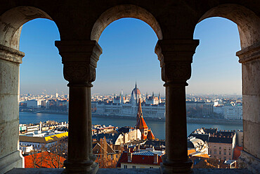 Parliament (Orszaghaz) and River Danube through arches of Fishermen's Bastion (Halaszbastya), UNESCO World Heritage Site, Buda, Budapest, Hungary, Europe