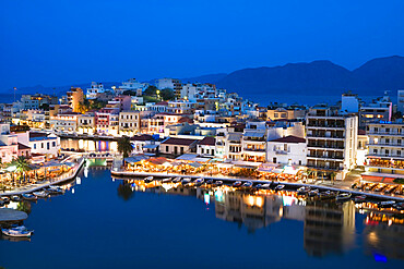 View over harbour and restaurants at dusk, Ayios Nikolaos, Lasithi region, Crete, Greek Islands, Greece, Europe