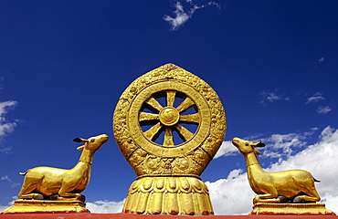 A golden dharma wheel and deer sculptures on the sacred  Jokhang Temple roof, Barkhor Square, Lhasa, Tibet, China