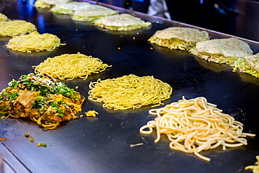 Okonomiyaki being prepared on a large griddle, Hiroshima, Japan, Asia