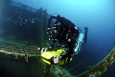 Mixed gas rebreather diver using scooter for mobility inside wreck.  Red Sea.