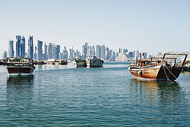 Downtown Doha with its impressive skyline of skyscrapers and authentic dhows in the bay, Doha, Qatar, Middle East