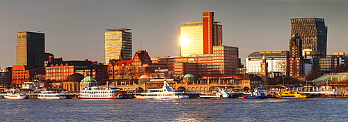 View from Elbe River to St. Pauli Landungsbruecken pier and skyscraper Tanzende Tuerme at sunset, St. Pauli, Hamburg, Europe