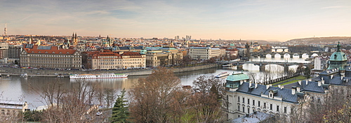 Panorama of the historical bridges and buildings reflected on Vltava River at sunset, Prague, Czech Republic, Europe