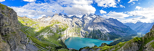 Aerial panoramic of Oeschinensee lake surrounded by woods in summer, Bernese Oberland, Kandersteg, Canton of Bern, Switzerland, Europe