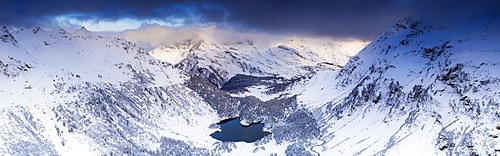 Aerial panoramic of Lake Cavloc and snowy woods, Bregaglia Valley, Engadine, canton of Graubunden, Switzerland, Europe