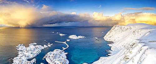 Burning sky at sunrise over the cold sea and Sorvaer village covered with snow, Soroya Island, Hasvik, Troms og Finnmark, Arctic, Norway, Scandinavia, Europe