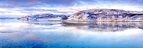 Clouds at sunset on snow capped mountains reflected in the clear water of Laksefjorden, Lebesby, Kunes, Troms og Finnmark, Arctic, Norway, Scandinavia, Europe