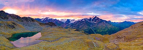 Pink sky at dawn on Forni Glacier and Tresero peak seen from lake Manzina, aerial view, Valfurva, Valtellina, Lombardy, Italy