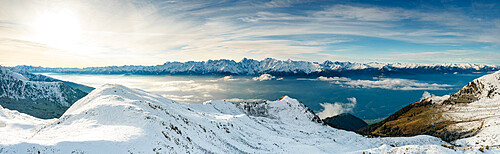 Snowcapped mountains surrounding Alpe Rogneda and Orobie Alps during a misty sunrise in autumn, Rhaetian Alps, Lombardy, Italy, Europe