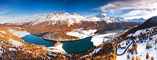 Colorful autumn trees surrounding lakes Champfer and Silvaplana with the snowcapped Piz Da La Margna in the background, Engadine, Graubunden, Switzerland, Europe