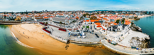 Aerial drone panoramic view of Ribeira beach with a ferris wheel set up during the winter months, Cascais, Portugal, Europe