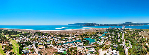 Aerial drone panoramic view of Troia, a peninsula located in Grandola Municipality, next to Sado River estuary, with Arrabida mountain range on left, Alentejo, Portugal, Europe