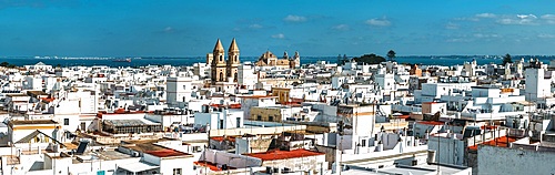 Aerial panoramic view of Cadiz, presenting its iconic rooftops and historic buildings under a bright sunny sky, capturing the city's rich architectural cultural heritage as the main port to the Americas during many centuries
