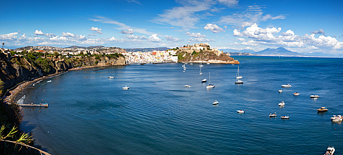 panoramic view of Coricella town, sea and castle on beautiful Procida island with colorful houses in sunny summer day Italy