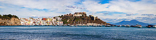 panoramic view of Coricella town, sea and castle on beautiful Procida island with colorful houses in sunny summer day Italy