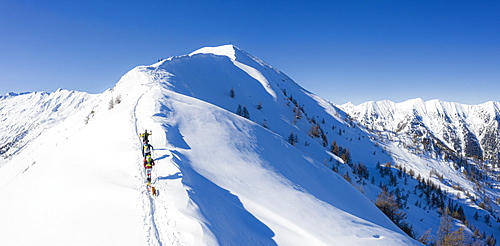 A team of three skiers advances on the mountain ridge, Mount Meriggio, Valtellina, Lombardy, Italy, Europe