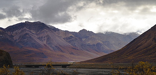 Tourist bus driving among mountains in the Denali National Park, Alaska, United States of America, North America