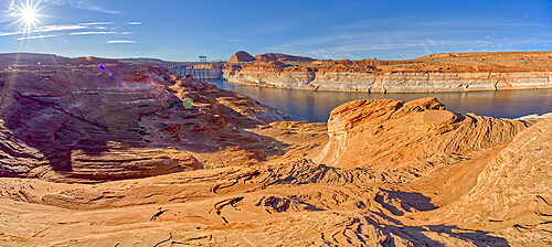 Wide angle view of Glen Canyon Dam from the wavy sandstone mesa of an area called the Chains, Arizona, United States of America, North America