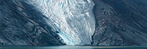 Panorama imag of glacier fingers coming down to seashore.