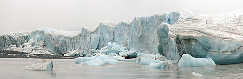 Panorama image of glacier face with zodiac crusing among the icebergs, Nunavut and Northwest Territories, Canada, North America