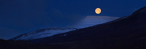 Panorama of full moon above snow covered mountains, Iceland, Polar Regions