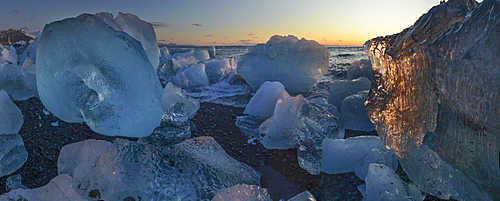 Pieces of glacial ice over black sand being washed by waves, Iceland, Polar Regions