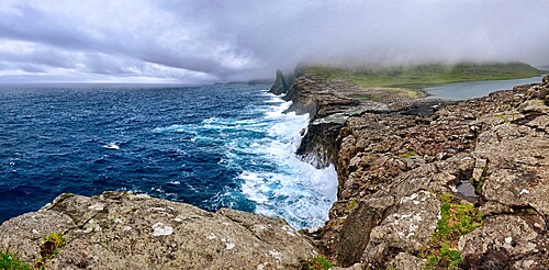 Panorama of Bosdalafossur, a waterfall that flows from the lake directly in the ocean, Faroe Islands, Denmark, Europe