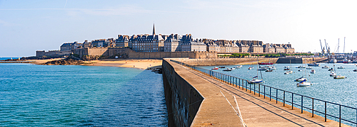 panoramic view of Saint-Malo walled city and harbor from stone pier in Brittany France