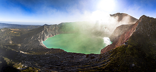 Aerial view of smoke above the turquoise lake on crater of Kawah Ijen volcano, Banyuwangi, East Java, Indonesia