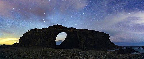 Silhouette of majestic natural stone arch Arco del Jurado under a starry night sky, Fuerteventura, Canary Islands, Spain