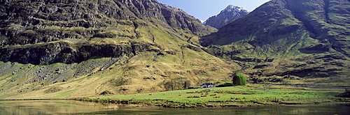 Mountain scenery and isolated farmhouse on shore of Loch Achtriochtan, Glencoe, Western Highlands, Scotland, United Kingdom, Europe