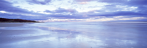 Beach at Alnmouth at dusk with dramatic clouds reflecting in wet sand at low tide, near Alnwick, Northumberland, England, United Kingdom, Europe