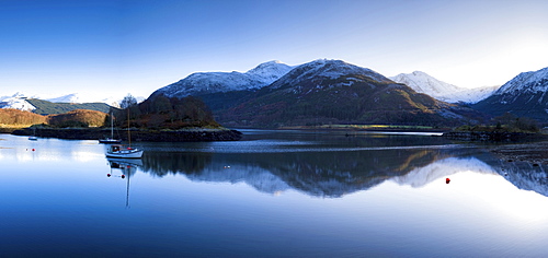 Winter view of flat calm Loch Leven with snow covered mountains reflected, near Ballachulish, Glencoe, Highland, Scotland, United Kingdom, Europe