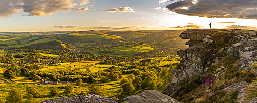 View of lone piper at at sunset on Curbar Edge, Curbar, Hope Valley, Peak District National Park, Derbyshire, England, United Kingdom, Europe