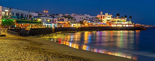 View of restaurants and shops overlooking Playa Blanca Beach at dusk, Playa Blanca, Lanzarote, Canary Islands, Spain, Atlantic, Europe