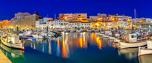 View of boats in marina overlooked by whitewashed buildings at dusk, Ciutadella, Menorca, Balearic Islands, Spain, Mediterranean, Europe