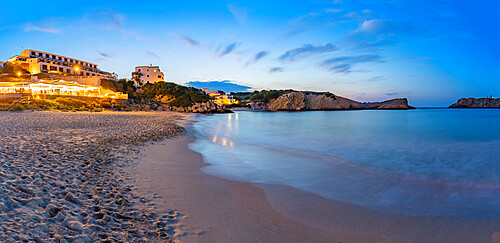 Hotels and whitewashed buildings overlooking beach at dusk in Arenal d'en Castell, Es Mercadal, Menorca, Balearic Islands, Spain, Mediterranean, Europe