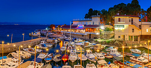 View of cafe and restaurant overlooking boats in harbour at dusk, Lovran village, Lovran, Kvarner Bay, Eastern Istria, Croatia, Europe