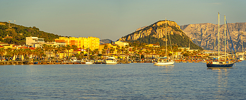 View of boats and colourful buildings at sunset in Golfo Aranci, Sardinia, Italy, Mediterranean, Europe