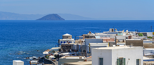 View of sea and whitewashed buildings and rooftops of Mandraki, Mandraki, Nisyros, Dodecanese, Greek Islands, Greece, Europe