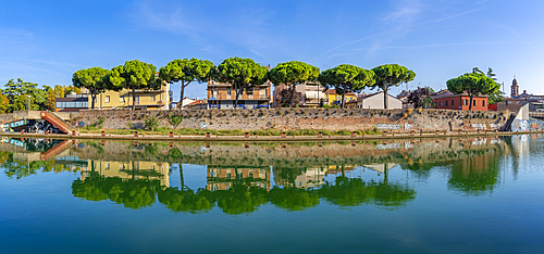 View of buildings and pine trees reflecting on the Rimini Canal, Rimini, Emilia-Romagna, Italy, Europe