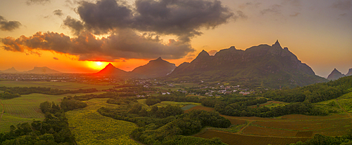 View of golden sunset behind Long Mountain and patchwork of green fields, Mauritius, Indian Ocean, Africa