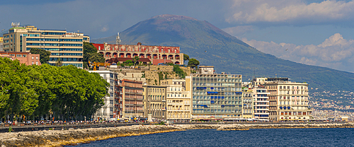 View of pastel coloured architecture, restaurants and cafes on seafront of Via Partenope and Mount Vesuvius, Naples, Campania, Italy, Europe