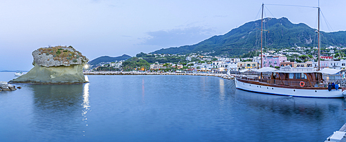 View of sailboat and town of Lacco Ameno at dusk, Island of Ischia, Campania, Italy, Europe